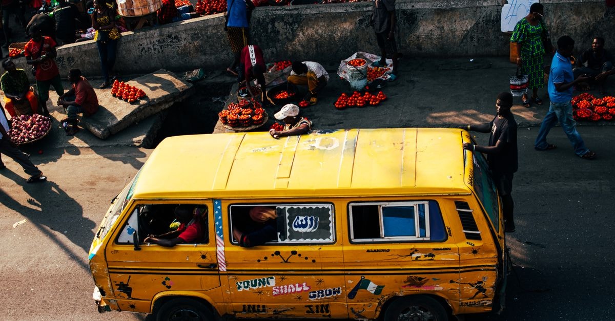 Alimosho, Nigeria Travel Guide: A Lagos Local Government Worth Knowing A bustling Lagos street scene featuring a vibrant yellow bus and a lively market atmosphere.