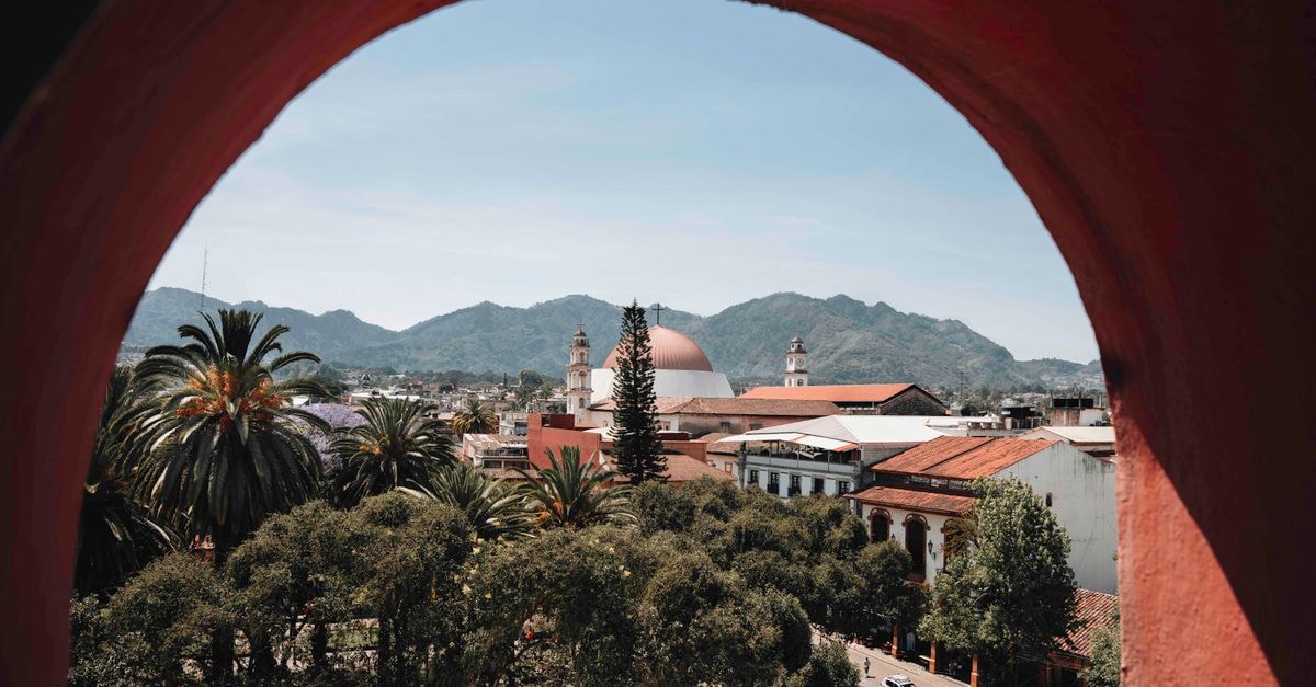 A stunning view of Huauchinango, Mexico with a historic church framed by vibrant nature and mountains.