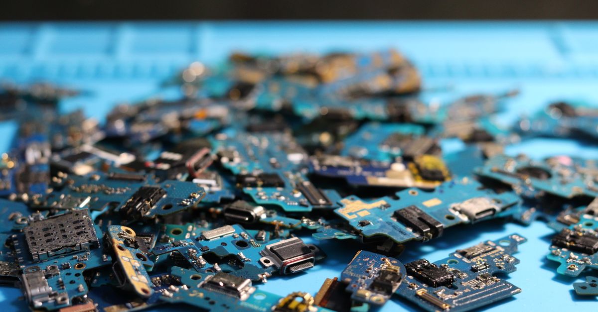 Samsung and Broadcom Sign $200 Billion AI Chip Partnership MOU Through 2030 Pile of disassembled circuit boards on a blue surface. Perfect for tech themes.