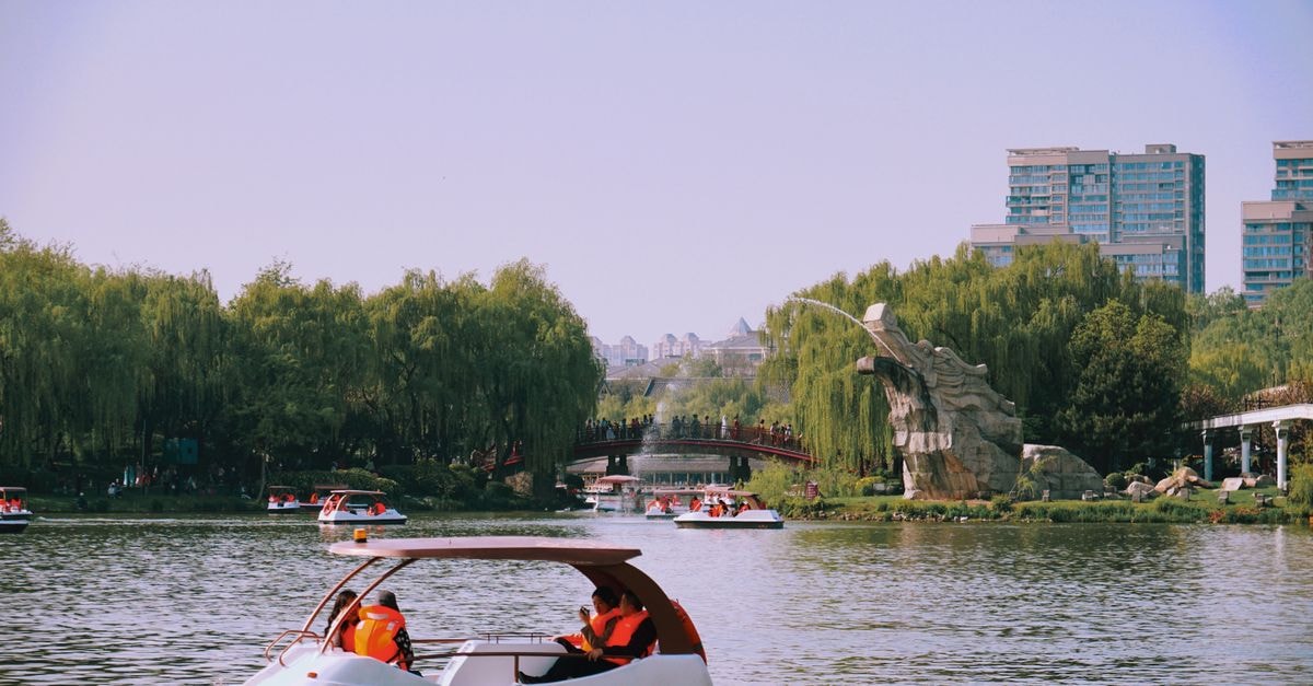 Dezhou Travel Guide: Planning Tips, Costs and Things to Do Enjoying a pedal boat ride on a peaceful pond surrounded by lush greenery in Xi'An, China.