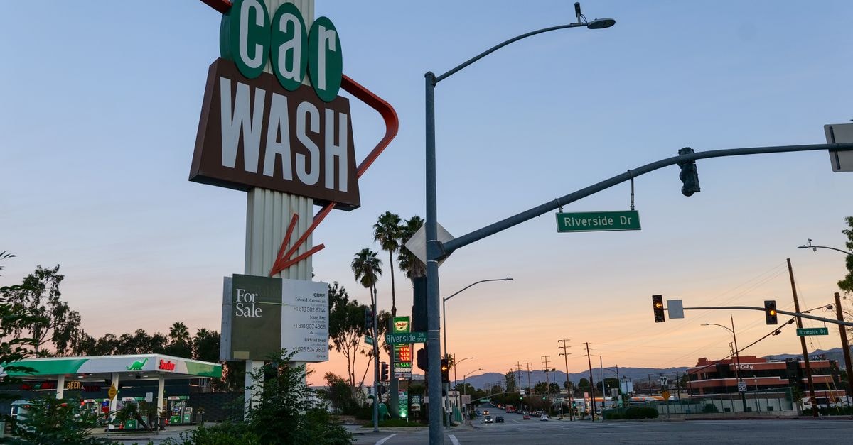 Riverside Travel Guide: Planning Tips, Costs and Things to Do A retro car wash sign at sunset on Riverside Drive with a gas station in the background.