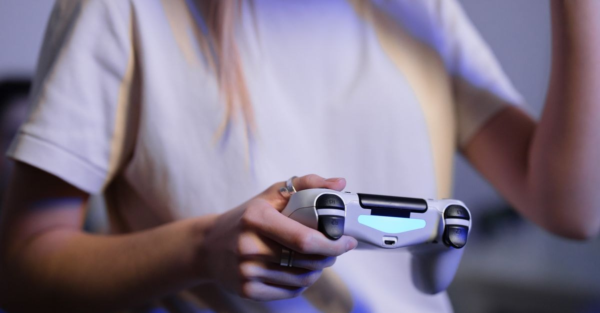 Sony CEO Totoki Says PlayStation 6 Launch Date Still Undecided Amid Memory Shortage Person playing video games with game controller in a relaxed setting.