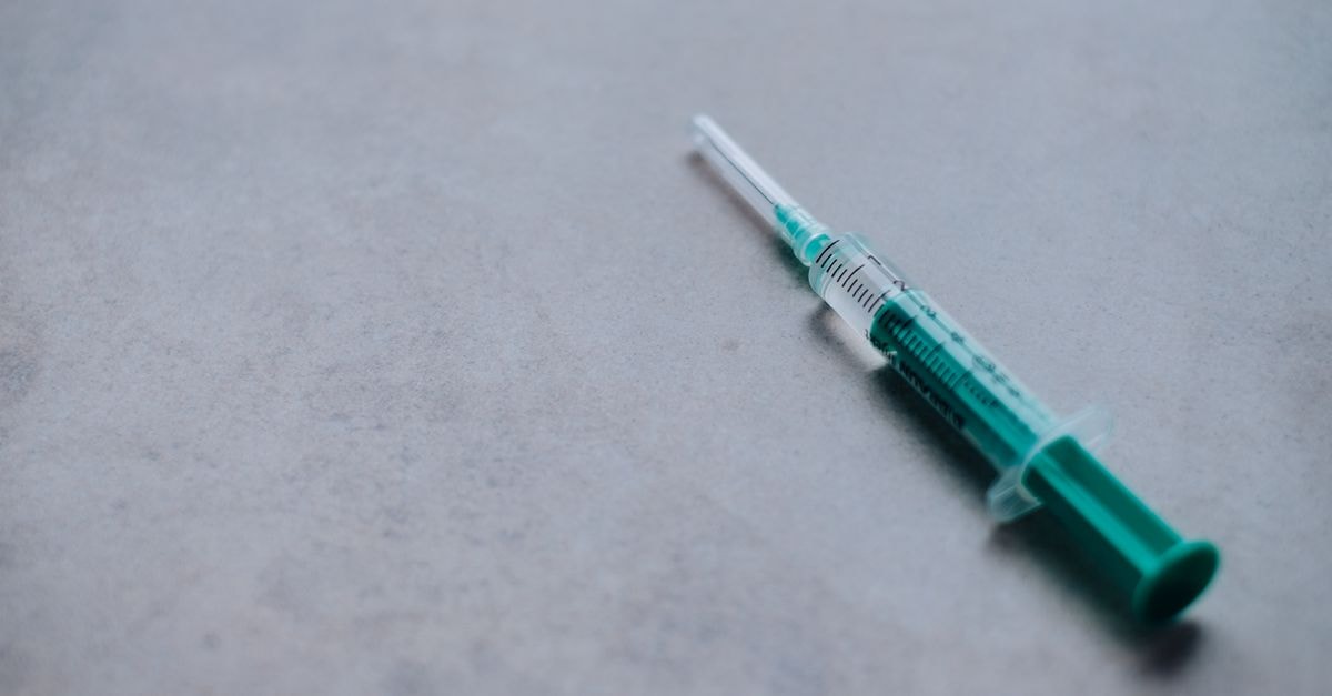 Global antibiotic overuse and Western Australia's missed flu targets mark latest healthcare developments Close-up of a green syringe on a gray surface, ideal for health and medical themes.