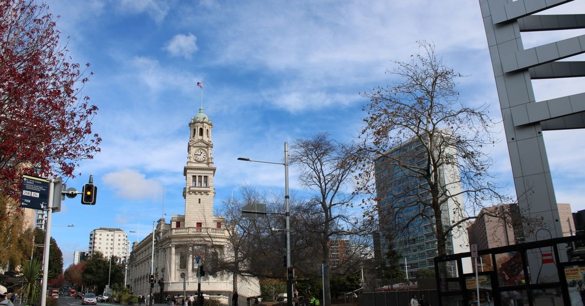 Hamilton, New Zealand Travel Guide: Gardens, River Parks and Easy Auckland Links Street view with a prominent clock tower and architecture in Auckland, New Zealand.