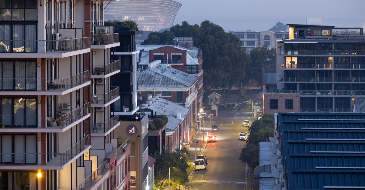 Aerial view of a city street lined with modern buildings at dusk, showcasing a serene urban landscape.