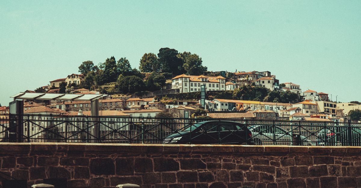 Residences Ouadada, Porto-Novo — A Cultural Oasis Charming hillside houses in Porto, Portugal, framed by lush greenery.