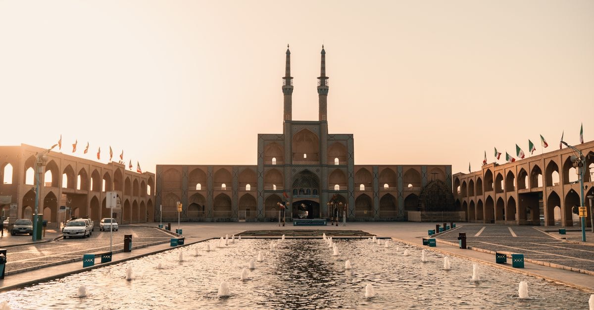 Visiting Qom: a thoughtful travel guide to Iran's sacred city View of the Amir Chakhmaq Complex in Yazd, Iran, at dusk with a serene fountain reflecting architecture.