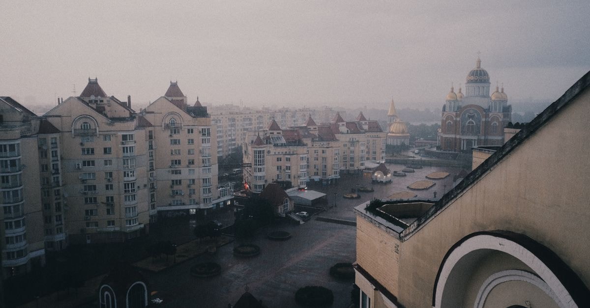 A high-angle view of a cityscape featuring unique architecture under an overcast sky.