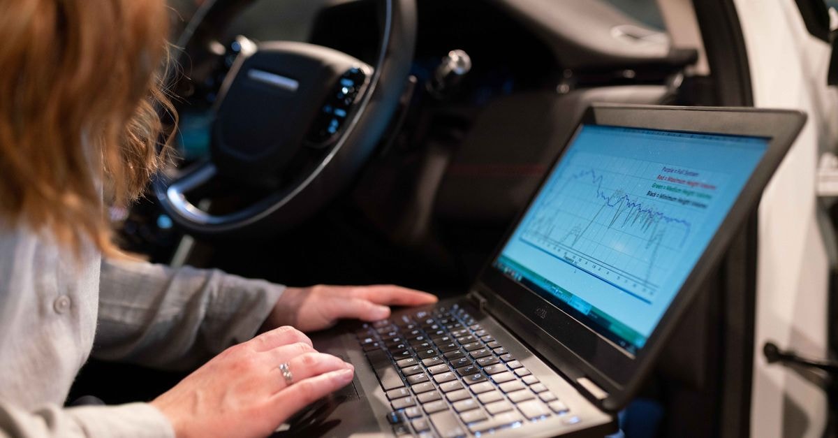 Tesla Engineers Audit Ningbo Suppliers as Optimus Production Push Intensifies Female engineer using laptop to analyze vehicle data inside a car for testing purposes.