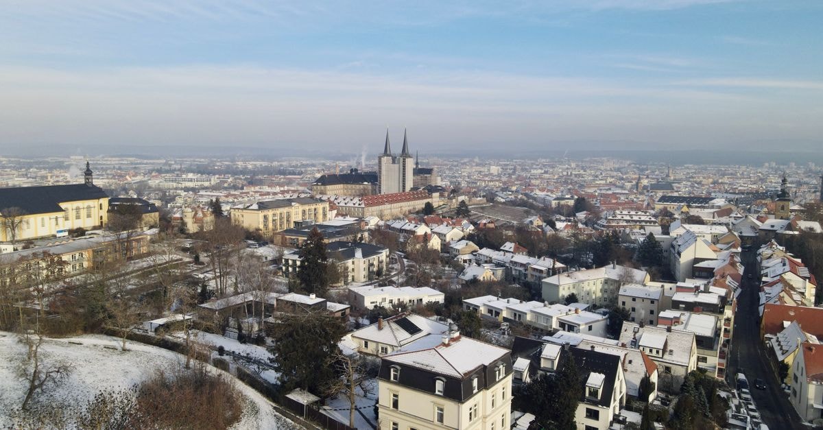 Hotel Krämerbrücke in Erfurt: A Bridge-Front Stay in the Old Town A stunning aerial view of a snow-covered cityscape with a prominent historical cathedral.