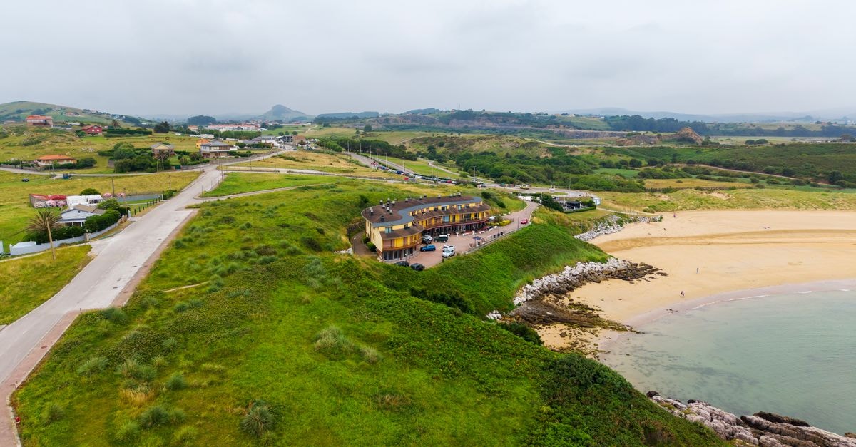 Posada Don Pablito in San Vicente: A Quiet Local Stay Aerial view of the green coastline and sandy beach in San Vicente de la Barquera, Cantabria, Spain.