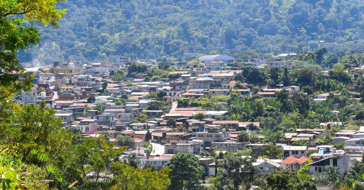 Captivating aerial view of a town surrounded by lush greenery in Ciudad de Guatemala, capturing the essence of local architecture.