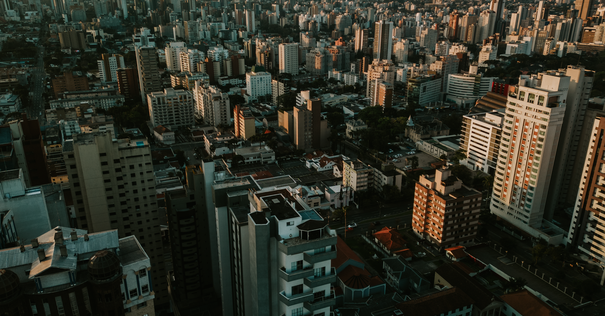 Hotel Posta del Sol in Paraná: Garden Stay with Seasonal Pool on Av. Uranga Stunning aerial view of Curitiba skyline at sunset featuring modern skyscrapers.