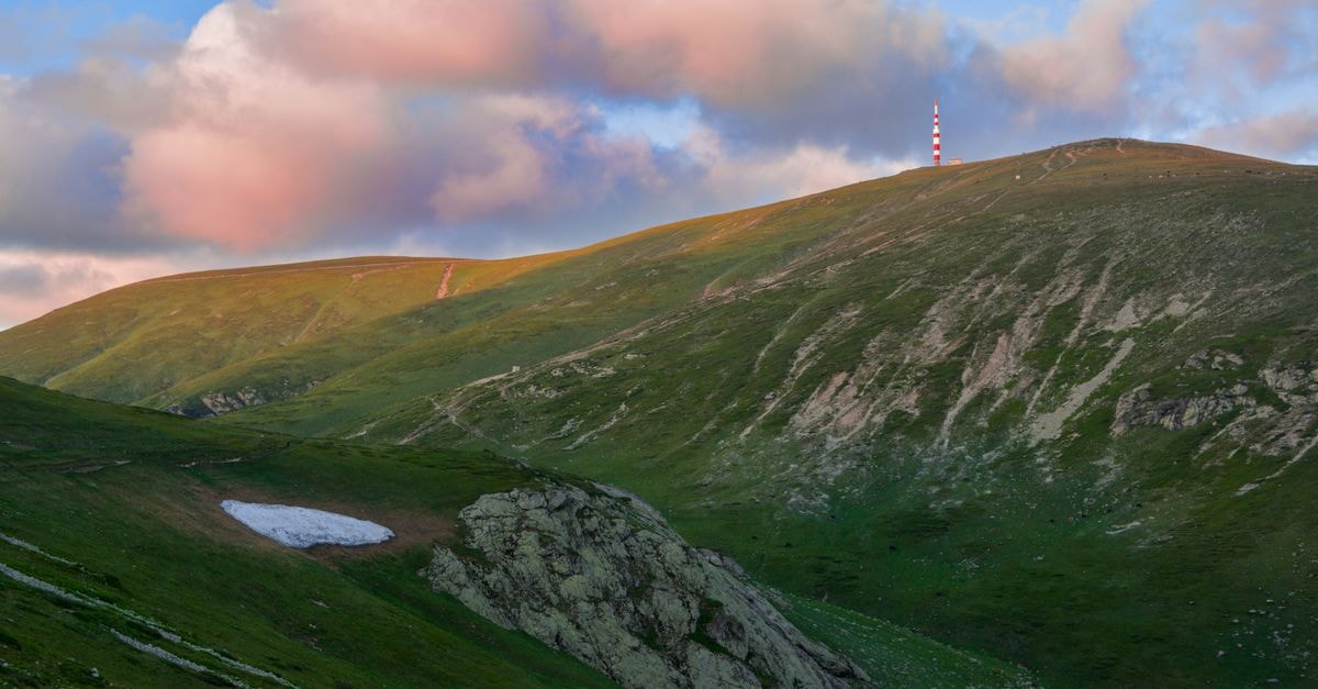 Gabrovo Hills in Gabrovo: Apartment-Style Stay With Mountain Views Vibrant sunset over Botev Peak in Bulgaria's Balkan Mountains with lush green hills.