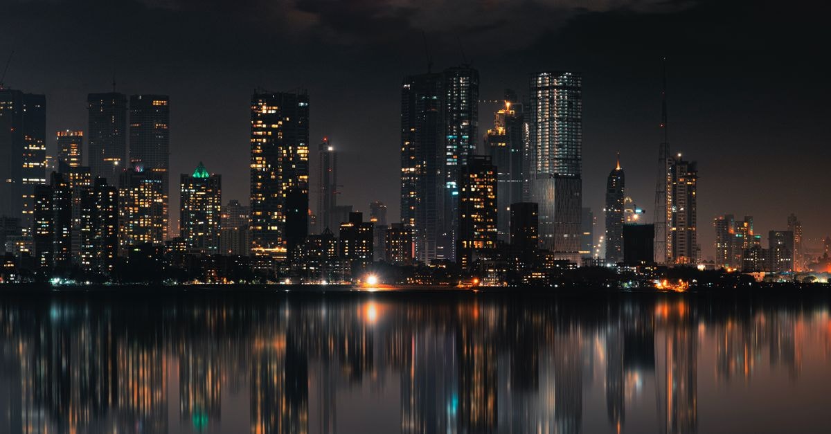 Naaz Executive Hotel in Mumbai: An Andheri-Kurla Road Stop With 24-Hour Room Service Captivating night view of Mumbai skyline with skyscrapers and reflections on still water.