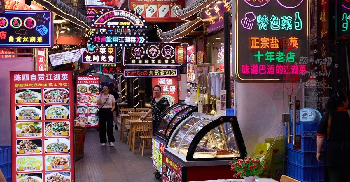 Explore a bustling night market with colorful neon signs and food vendors.