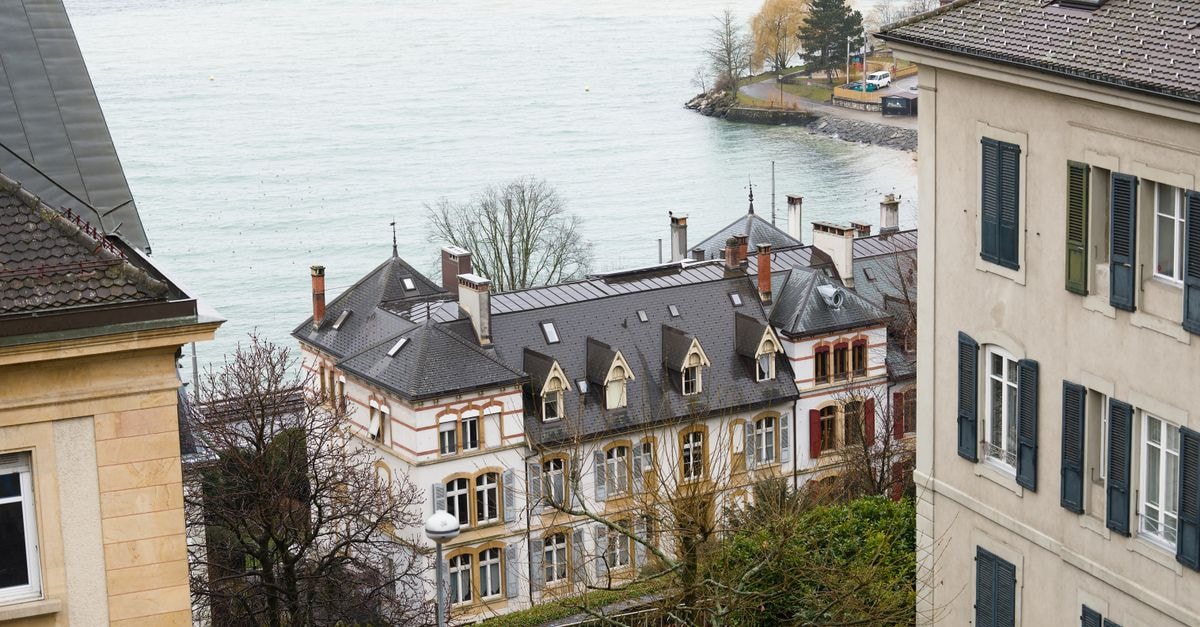 Ibis Lausanne Centre in Lausanne: A Pocket-Sized Launchpad in the City Elegant Swiss architecture overlooking Lake Neuchâtel on a calm day.