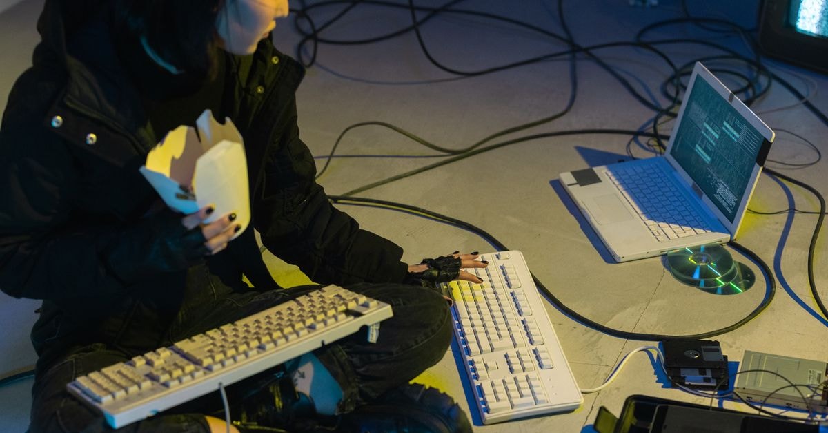 Qwen and Zhipu roll out on-the-ground Hangzhou campaigns to compete for developer and entrepreneur users A young woman in a dark room surrounded by computers and cables, eating and typing on keyboards.