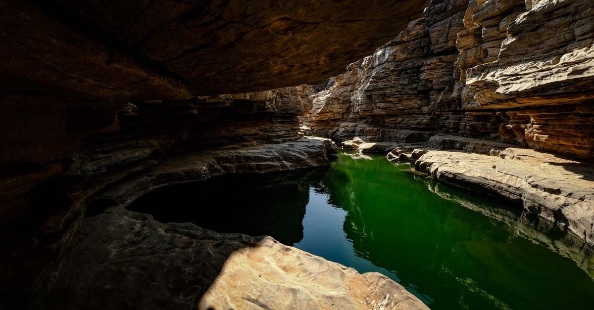 Kimberley Travel Guide: Planning Tips, Costs and Things to Do Explore the enchanting beauty of a limestone cave with a serene reflection pool beneath.