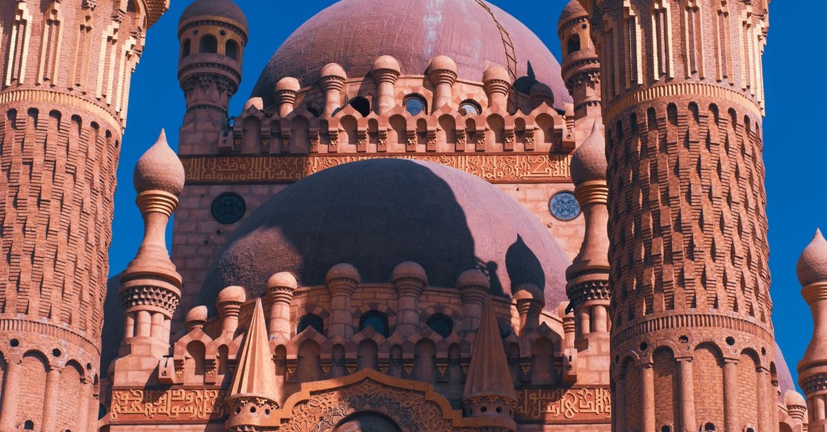 Khartoum Travel Guide: Planning Tips, Costs and Things to Do Close-up of the ornate Sahaba Mosque minarets and dome in Sharm El Sheikh under a clear blue sky.