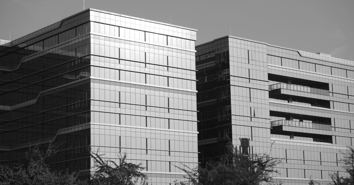 Blackstone’s Knowledge Realty Trust OFS subscribed 1.4 times on Day 1 Black and white photo of modern office buildings in Bengaluru, India, showcasing architectural design.
