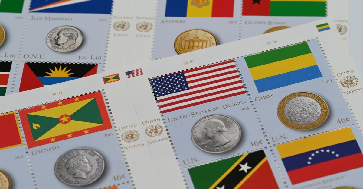 Bissau Travel Guide: A Slow, Salt-Air Welcome to Guinea-Bissau A close-up of international stamps and coins featuring country flags, promoting global culture.
