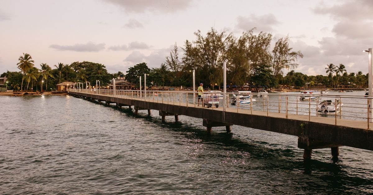 Suva Travel Guide: Planning Tips, Costs and Things to Do A tranquil pier extending into the water at sunset in Bahia, Brazil capturing serene vacation vibes.