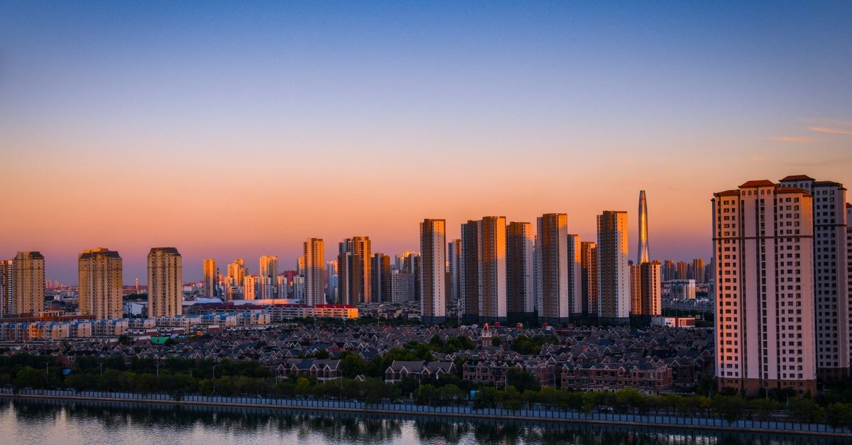 Holiday Inn Express Jinan High-Tech Zone, Jinan — Jingshi Road Convenience A stunning urban skyline showcasing skyscrapers by the river during sunset.