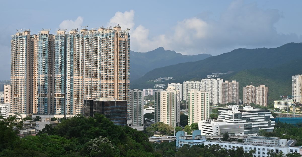 Nina Hotel Tsuen Wan West in Tsuen Wan: A Skyline Hub Above the District Urban skyline of Hong Kong featuring towering skyscrapers against lush mountains.