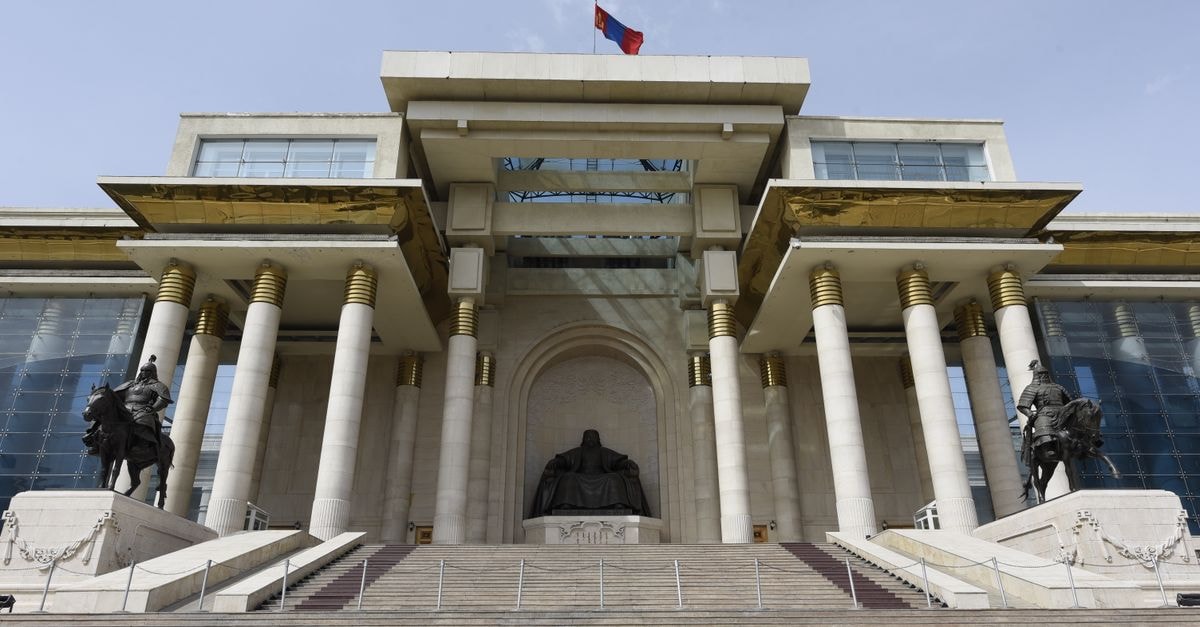Ulaanbaatar Travel Guide: A Quiet Look at Mongolia's Capital Front view of the historic Government Palace in Ulaanbaatar with Genghis Khan statue and columns.