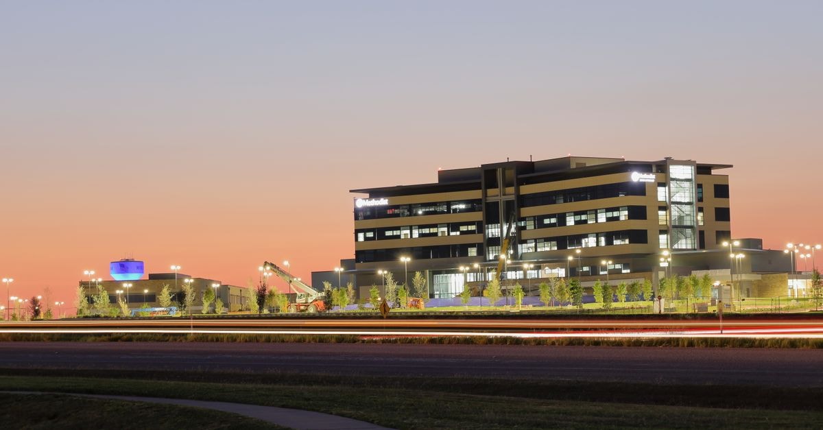 Brinker International: Franchise-Heavy Casual Dining With a Tight Cash-Flow Margin of Safety A modern building illuminated at sunset, featuring a sleek design and vibrant sky in Texas, USA.