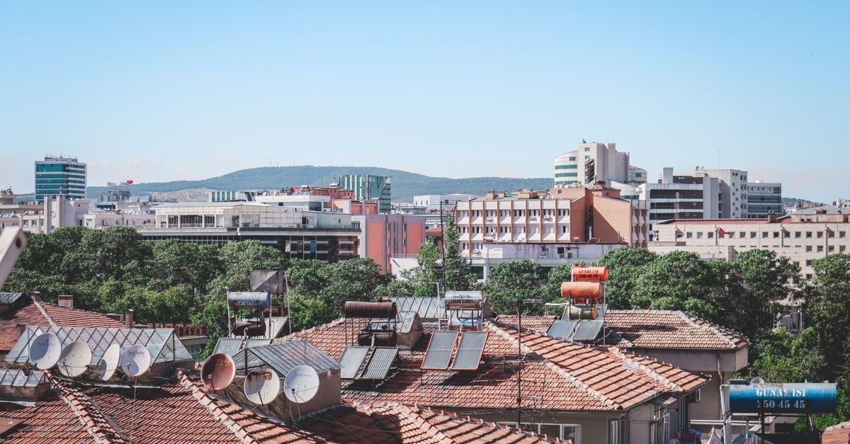 Strimon Garden SPA Hotel in Kyustendil: Mineral Pools and a Restored Aristocratic Building Aerial cityscape of Gaziantep, Turkey, showcasing urban rooftops with solar panels under a bright summer sky.