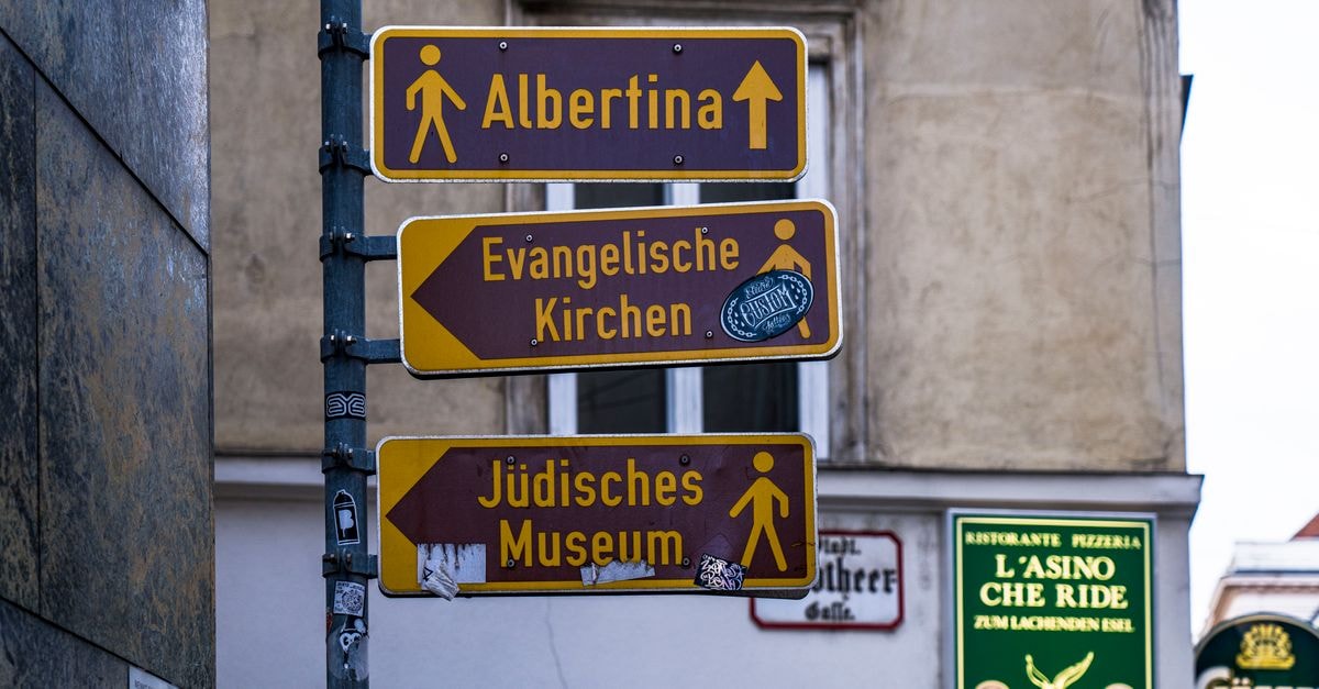 Olathe Travel Guide: Arts, Farmsteads & Downtown Days Street signs in Vienna guide tourists to Albertina, Evangelische Kirchen, and Jüdisches Museum.