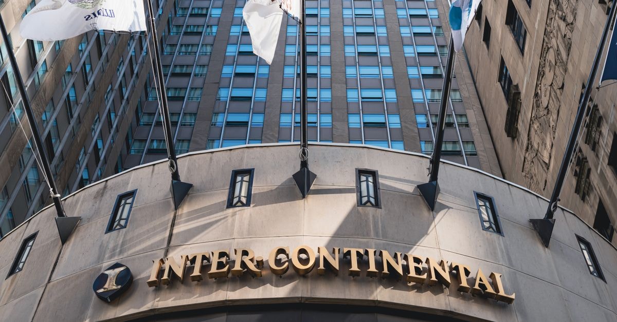 Low angle shot of InterContinental Hotel in Chicago, showcasing architectural design and flags.