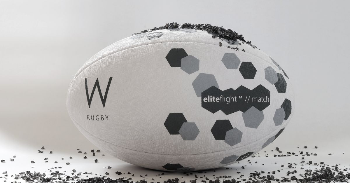 Fiji Drua Women chase historic Super W title as rugby brain injury lawsuit risks collapse Close-up of a W rugby ball featuring hexagonal patterns on a clean, white background with scattered black granules.