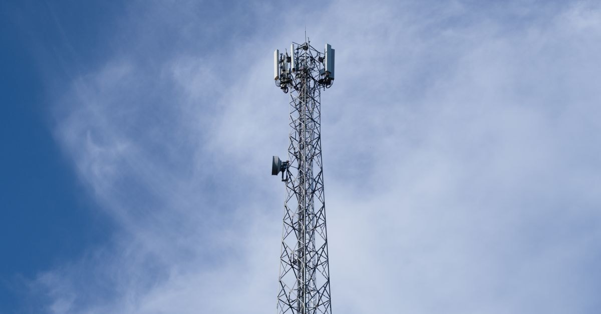 Mobilicom 推出 SwarmiX,鎖定集群規模網狀網路 一座高大的金屬通訊塔聳立於背景為晴朗藍天與點綴雲朵的天空之前。