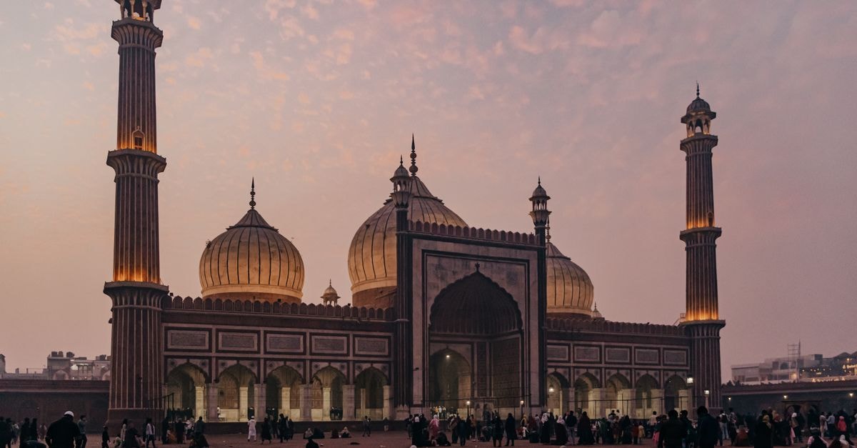 A stunning view of Jama Masjid in Delhi at dusk, showcasing Mughal architecture and vibrant evening sky.