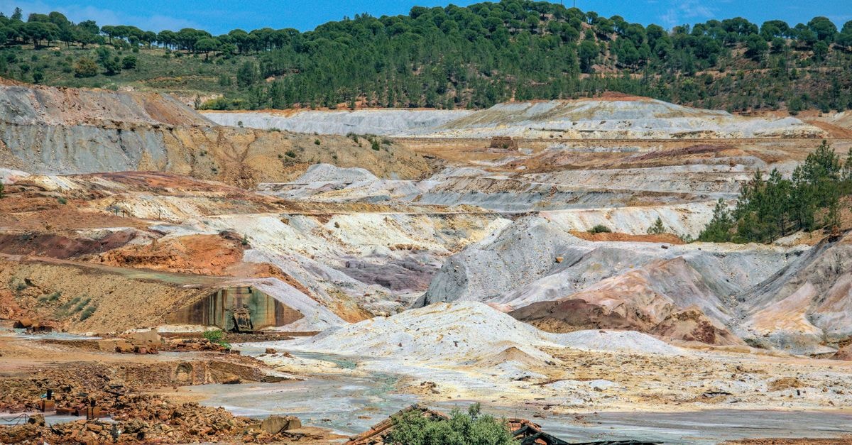 Sigma Lithium posts record Q2 revenue but EPS misses as Minas Gerais dispute halts operations A vast industrial mining landscape in Minas de Riotinto, showcasing the earthy textures and mineral colors.