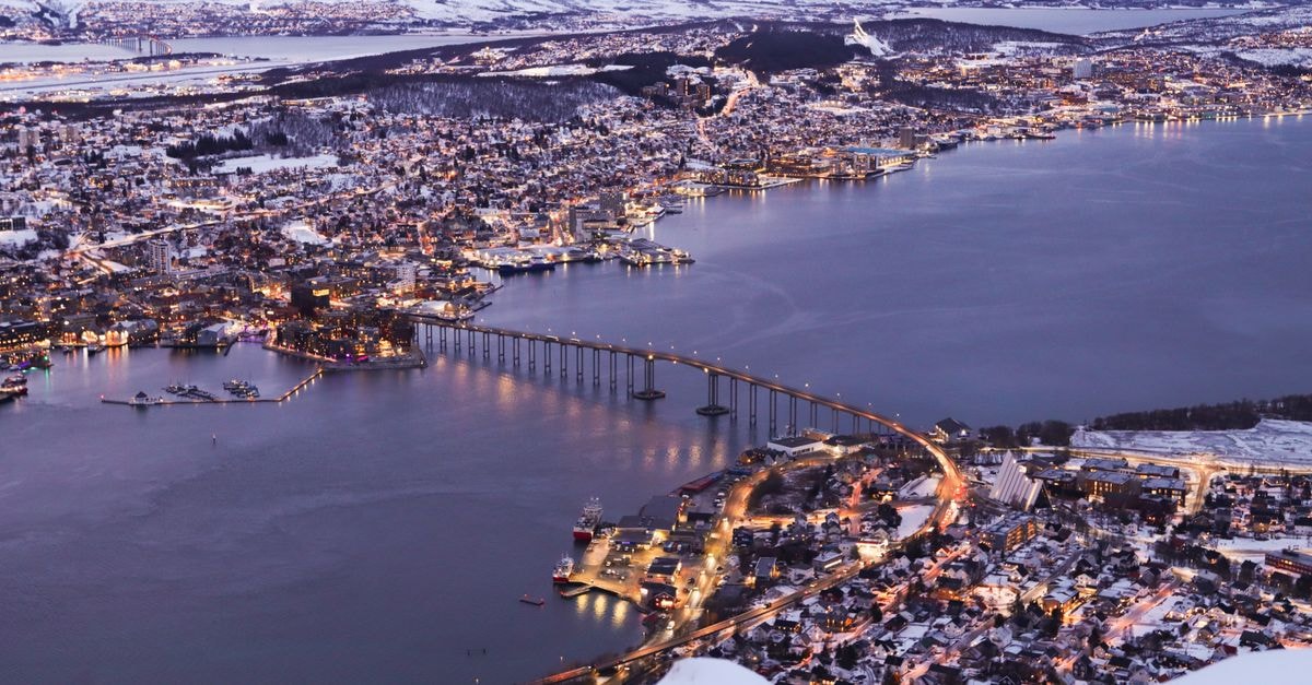 Tromsø Travel Guide: Planning Tips, Costs and Things to Do Stunning aerial twilight view of Tromsø's cityscape and snowy landscapes in winter.