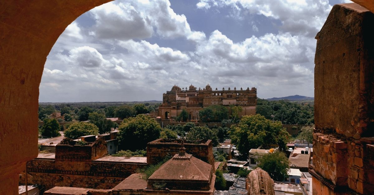 Hotel Man Mandir, Gwalior: A Practical Stay on Old High Court Road View of Orchha Fort in India framed by ancient architecture, under a cloudy sky.