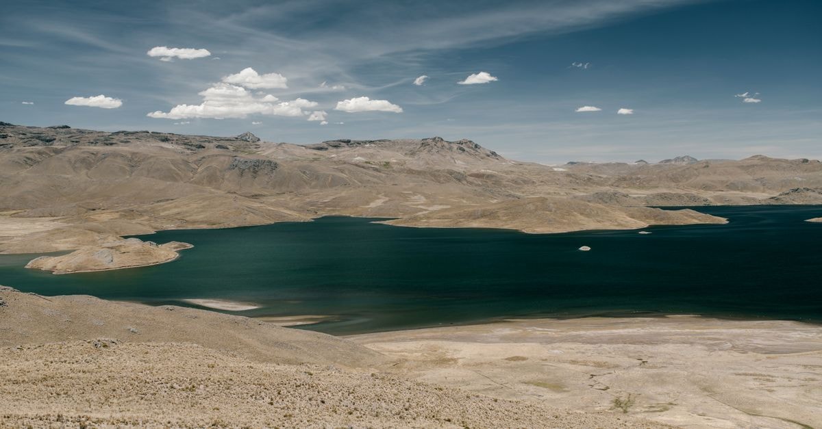 An Oruro Travel Guide to Bolivia's High-Altitude Cultural Heart Scenic view of a tranquil lake amidst arid mountains under a clear blue sky in Bolivia.