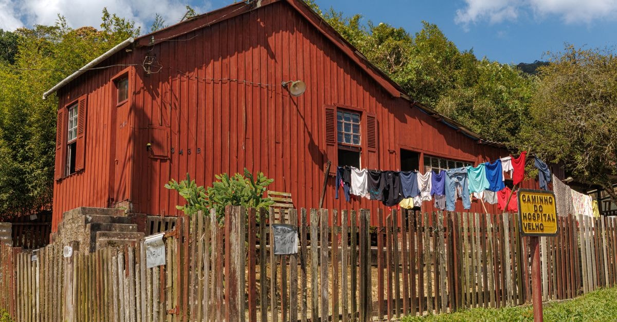 São Carlos Travel Guide: Planning Tips, Costs and Things to Do Rustic red house with laundry line on wooden fence in scenic Paranapiacaba, São Paulo, Brazil.
