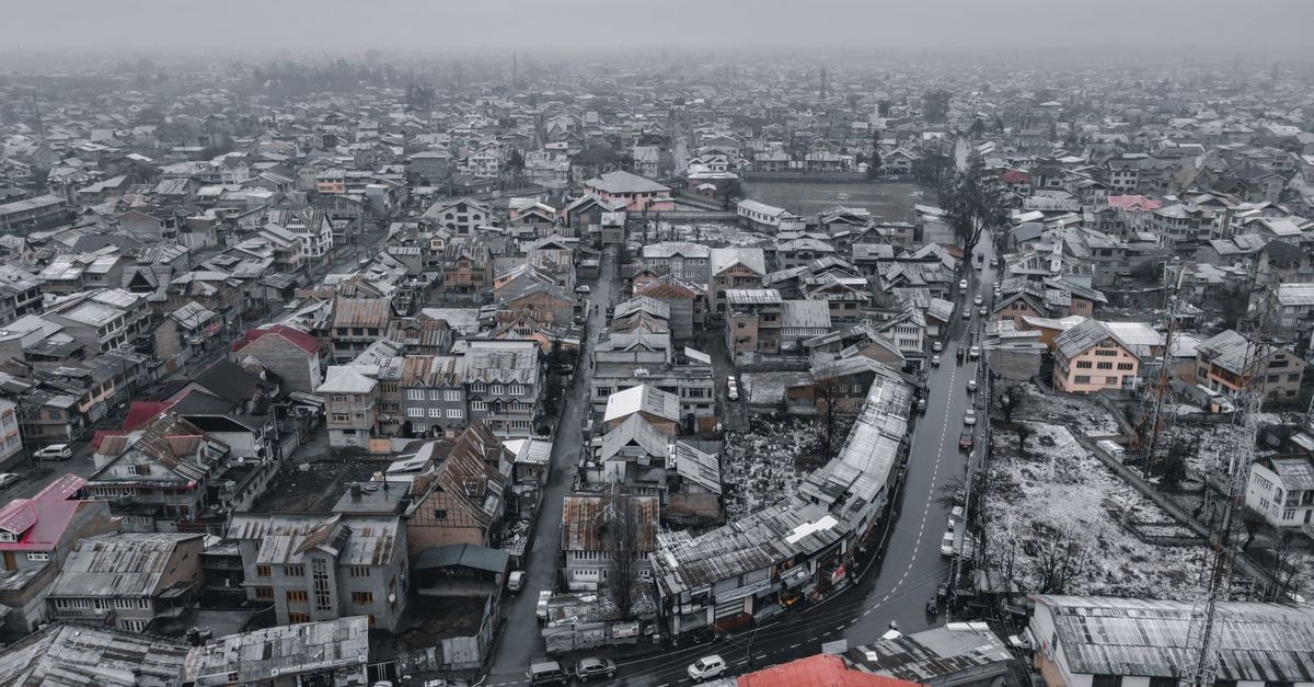 冬季斯利那加市區的空拍雪景，呈現屋頂與蜿蜒的道路。