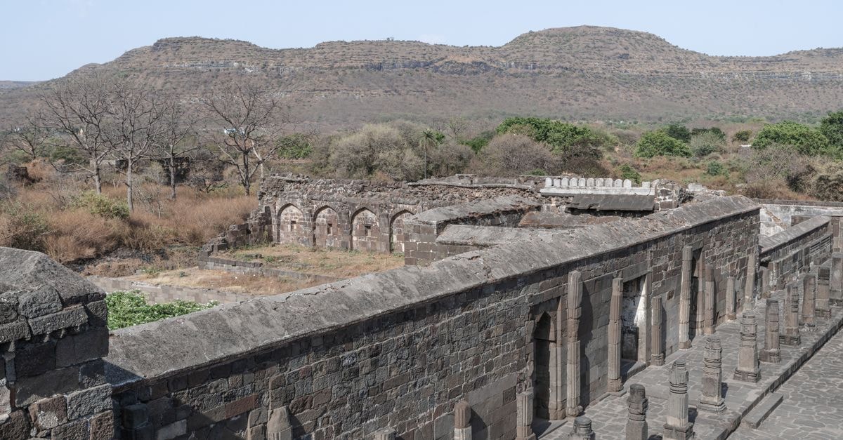 Explore the ancient stone architecture of Daulatabad Fort in Maharashtra, India, with scenic views of the landscape.