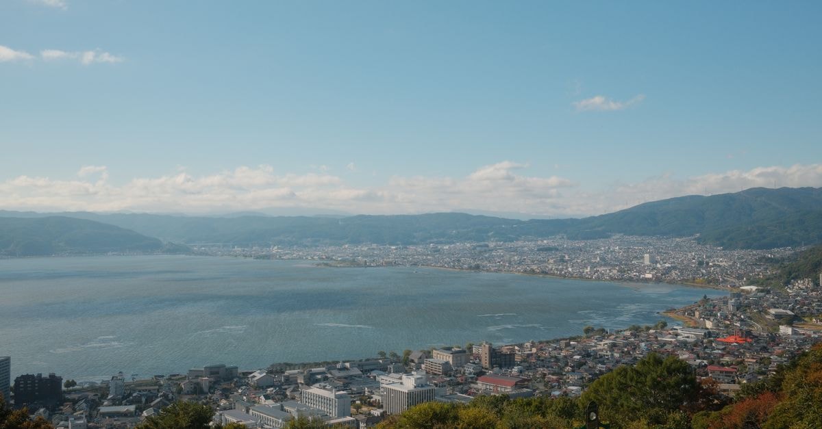 Akita Travel Guide: Quiet Corners, Clear Lakes, and a Calmer Pace Breathtaking aerial view of Lake Suwa and surrounding cityscape in Nagano, Japan on a clear day.