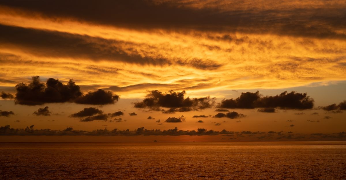 Classic Kinabalu Hotel in Kota Kinabalu: A Hillside Stop Near the Markets Vibrant sunset over the ocean in Kota Kinabalu, with golden clouds and serene waters.