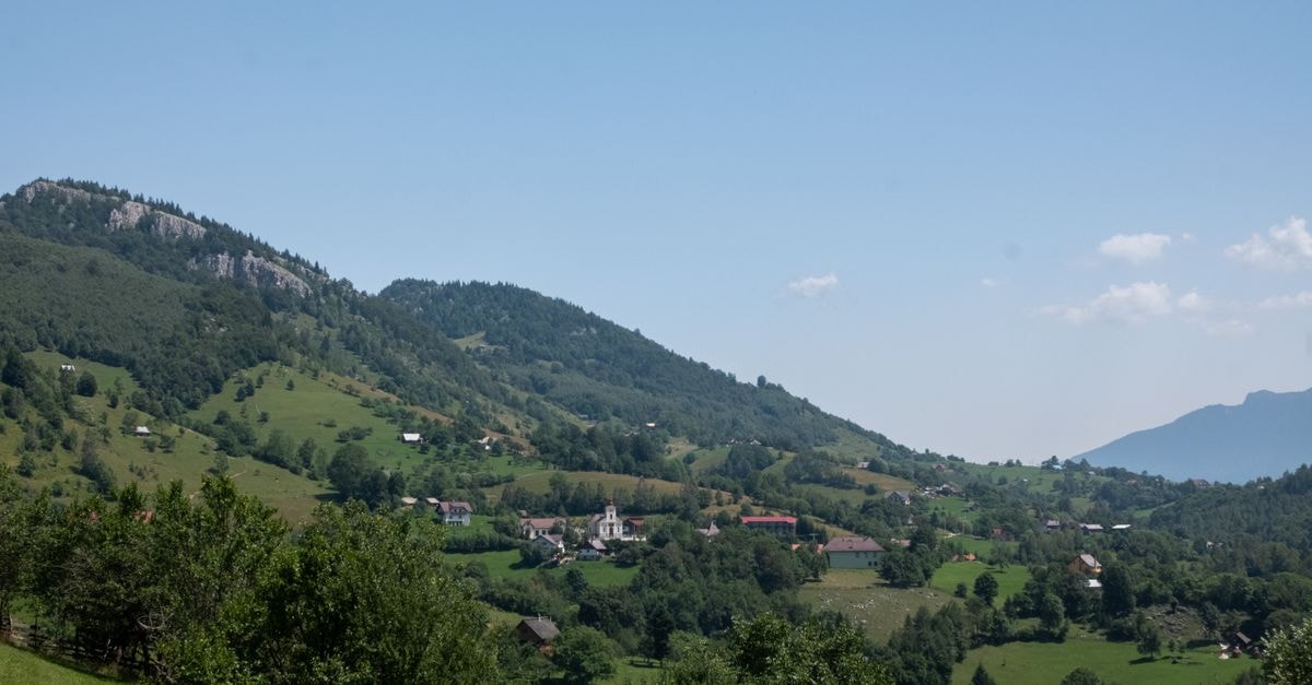 Brasov Travel Guide: Planning Tips, Costs and Things to Do Beautiful summer view of the lush hills and village in Măgura, Brașov, Romania.