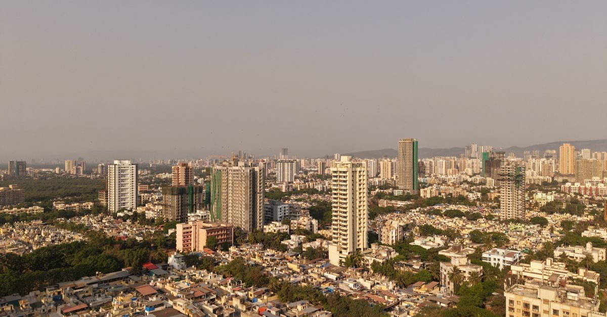 A breathtaking aerial view of Mumbai's sprawling cityscape featuring tall skyscrapers and dense urban areas.