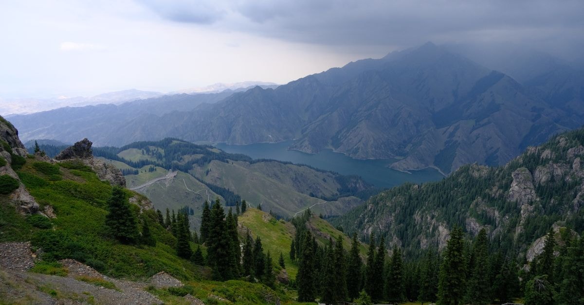 Urumqi Travel Guide: Markets, Museums, and Mountain Air Scenic landscape of Sary-Chelek Lake surrounded by majestic mountains and lush greenery in Kyrgyzstan.