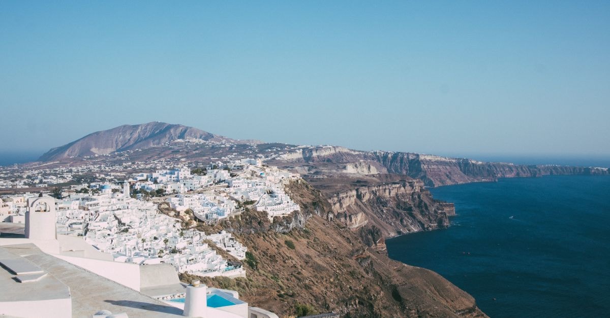 Fira Travel Guide: Cliff-Top Calm in Santorini's Capital A stunning aerial view of Santorini's iconic white buildings and the deep blue Aegean Sea.